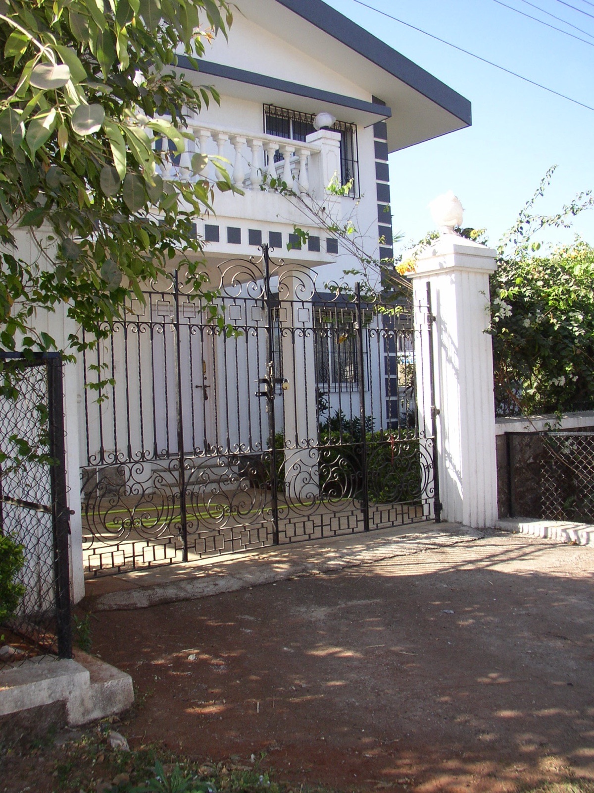 Capped gate piers and a wrought-iron gate